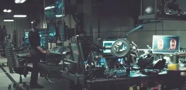 Batman aka Bruce Wayne next to the chair and desking in the Batcave in Batman v Superman