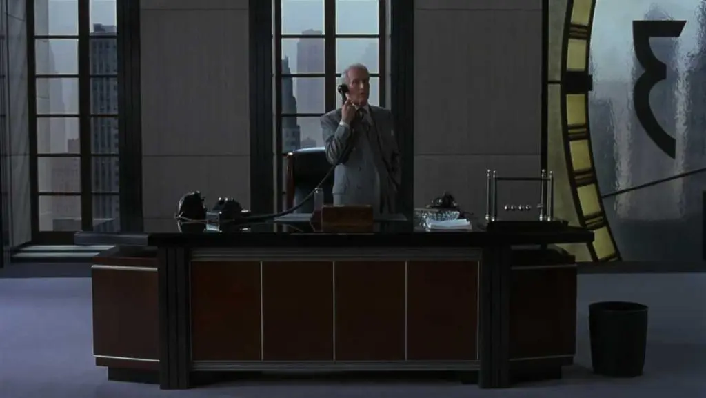 Ballrace, by Loncraine Broxton, a stylish chrome version of Newton's cradle, on the desk of Sidney J. Mussburger (Paul Newman) in The Hudsucker Proxy
