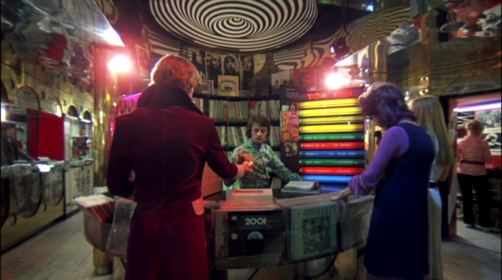 Alex collects his pre-ordered records from a booth in the record store in A Clockwork Orange