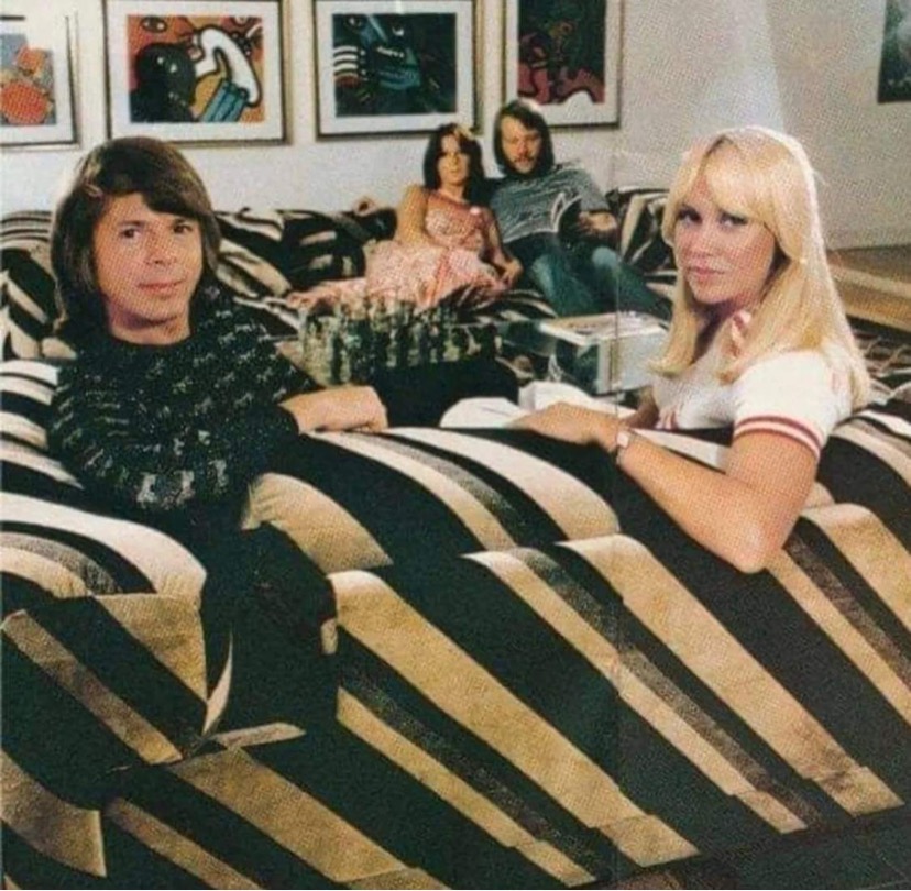 ABBA photographed sitting in a pair of Howard Keith Diplomat sofas in striped velour fabric. Image c/o Solid State Vintage