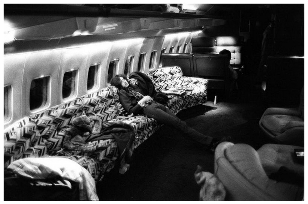 Jimmy Page of Zed Zeppelin relaxing on a 70s sofa onboard the private jet Starship